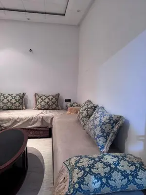 a room with two beds with pillows and a table at Appartement à Rabat in Rabat