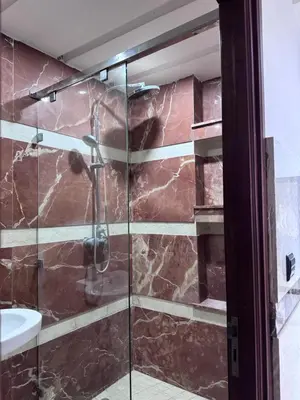 a bathroom with a glass shower with a sink at Appartement à Rabat in Rabat