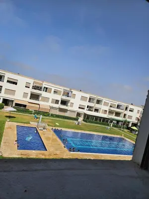 a large building with a swimming pool in front of it at vacance à Mansouria P Banus in Mansouria