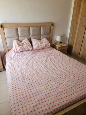 a bedroom with a bed with an orange bedspread and pillows at vacance à Mansouria P Banus in Mansouria