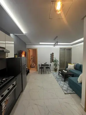 a living room with a blue couch and a table at Sublime Cozy Chic Studio Condo in Downtown Casablanca in Casablanca