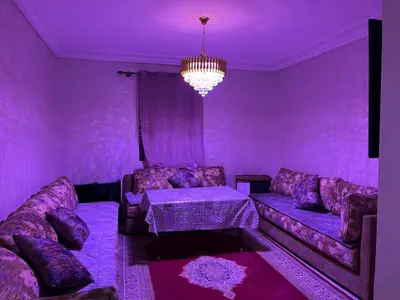 a purple living room with a couch and a table at Appartement Magnifique au coeur de la Corniche de Rabat in Rabat