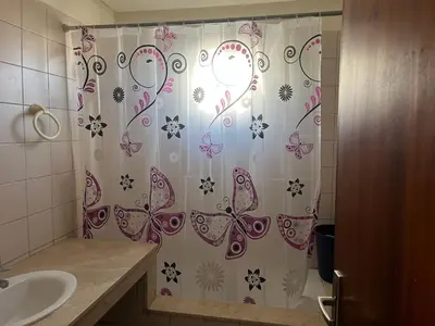 a bathroom with a shower curtain with butterflies on it at Appartement Magnifique au coeur de la Corniche de Rabat in Rabat