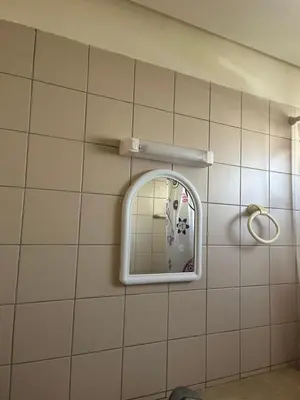 a bathroom with a mirror on a tiled wall at Appartement Magnifique au coeur de la Corniche de Rabat in Rabat