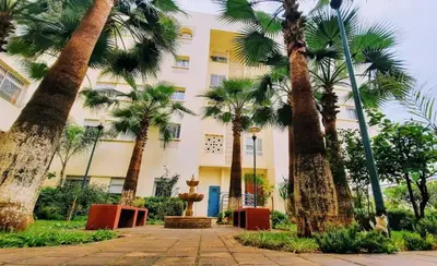 a group of palm trees in front of a building at Appartement Magnifique au coeur de la Corniche de Rabat in Rabat