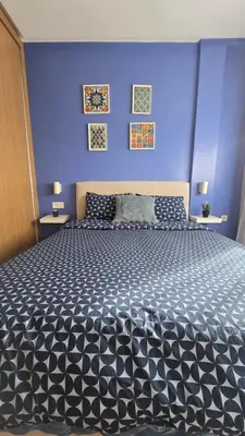 a bedroom with a large bed with a blue wall at Nice Studio Casablanca Mohammed V Airport in Derroua