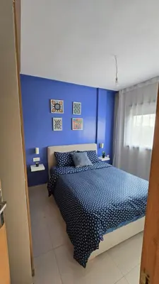 a blue bedroom with a bed with a blue wall at Nice Studio Casablanca Mohammed V Airport in Derroua