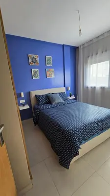 a blue bedroom with a bed and a blue wall at Nice Studio Casablanca Mohammed V Airport in Derroua