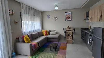 a living room with a couch and a kitchen at Nice Studio Casablanca Mohammed V Airport in Derroua
