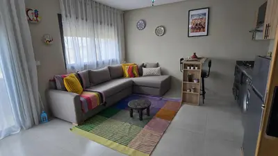 a living room with a couch and a table at Nice Studio Casablanca Mohammed V Airport in Derroua
