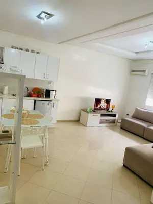 a kitchen and living room with a table and a couch at Résidence journalière in Casablanca