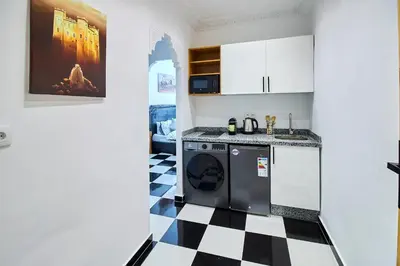 a kitchen with a black and white checkered floor at Luxury Moroccan Studio in Casablanca