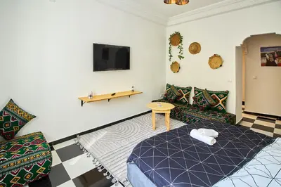 a room with a couch and a table and a tv at Luxury Moroccan Studio in Casablanca