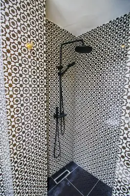 a shower in a bathroom with a black and white pattern at Luxury Moroccan Studio in Casablanca