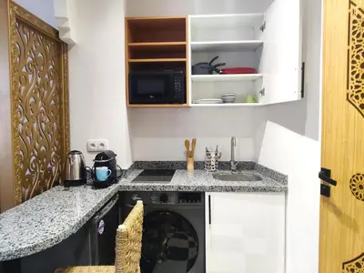 a small kitchen with a sink and a microwave at Suite DeLuxe au coeur de la ville in Casablanca