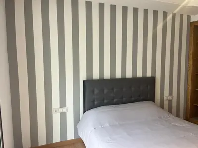 a bedroom with a bed with striped walls at downtown luxurious flat quartier Gauthier in Casablanca