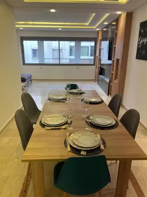 a wooden table with chairs and plates and wine glasses at downtown luxurious flat quartier Gauthier in Casablanca