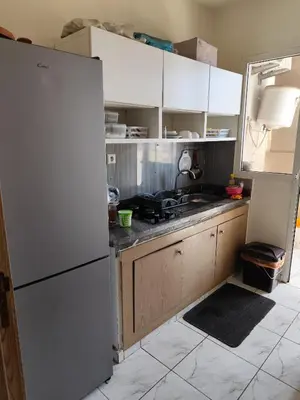 a kitchen with white cabinets and a white refrigerator at Alia Apartment 25 in Casablanca