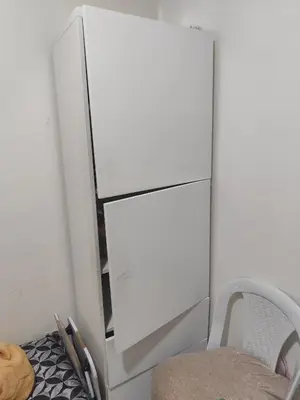 a white refrigerator in a room with a chair at Alia Apartment 25 in Casablanca