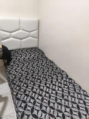 a bed with a black and white comforter at Alia Apartment 25 in Casablanca