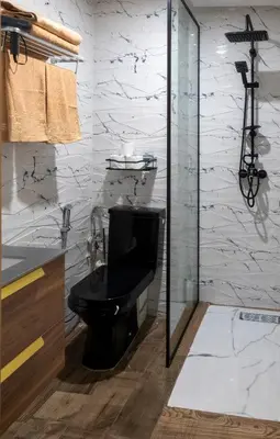 a bathroom with a black toilet and a shower at Elégant et moderne appartement à 10 min du centre de Casablanca in Casablanca