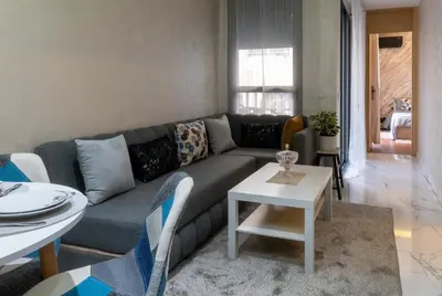 a living room with a couch and a table at Elégant et moderne appartement à 10 min du centre de Casablanca in Casablanca