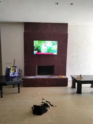 a living room with a fireplace and a tv at Ferme a Ain Tizgha Benslimane in O Ben Slimane