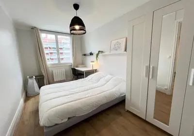 a bedroom with a large white bed and a window at Appartement cosyy in Casablanca