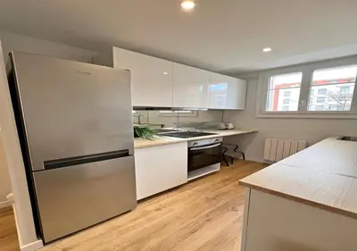 a kitchen with white cabinets and a stainless steel refrigerator at Appartement cosyy in Casablanca