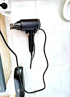 a hair dryer hanging on a wall in a bathroom at Suite des lumières Al Malaki Offre Spéciale front Mer, Zéro Surprise- l'Accueil Aéroport & Service Cuisine si besoin de Tranquillité Totale in Rabat