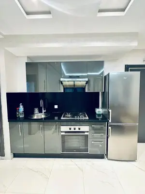 a kitchen with stainless steel appliances and a refrigerator at Résidence Sheren in Casablanca