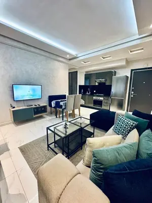 a living room with a couch and a tv at Résidence Sheren in Casablanca