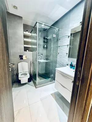 a bathroom with a glass shower and a toilet at Résidence Sheren in Casablanca
