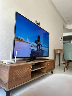 a large flat screen tv on a wooden entertainment center at Résidence sheren in Casablanca