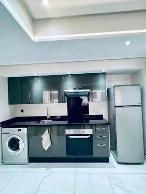 a kitchen with a refrigerator and a sink and a dishwasher at Résidence sheren in Casablanca