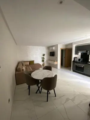 a living room with a couch and a table and chairs at Résidence Sheren in Casablanca