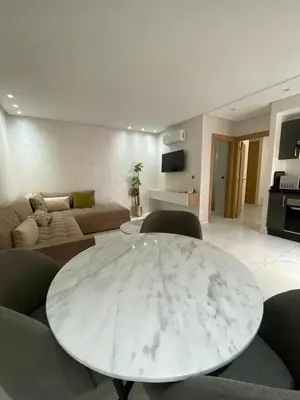 a living room with a table and a couch at Résidence Sheren in Casablanca