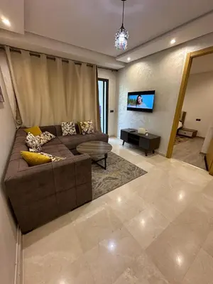 a living room with a brown couch and a tv at Res in Casablanca