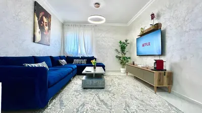 a living room with a blue couch and a tv at T6 Luxury in Témara Discover a Comfortable Apartment in Temara