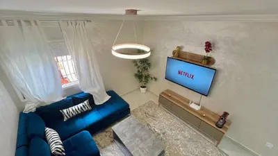 a living room with a blue couch and a tv at T6 Luxury in Témara Discover a Comfortable Apartment in Temara