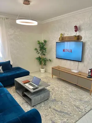 a living room with a blue couch and a tv at T6 Luxury in Témara Discover a Comfortable Apartment in Temara