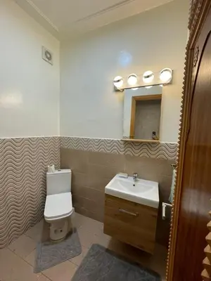 a bathroom with a sink and a toilet and a mirror at Al Kawtar in Mansouria