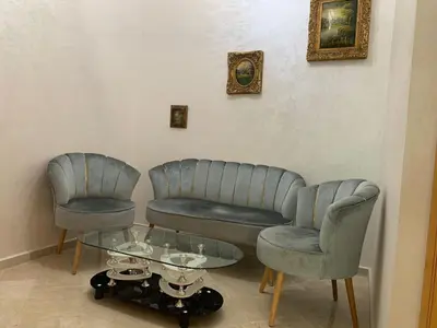 a living room with two chairs and a glass table at Al Kawtar in Mansouria