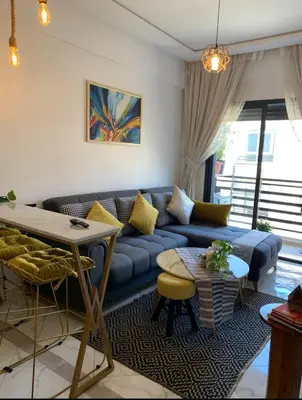 a living room with a blue couch and a table at Hay al qods in Casablanca