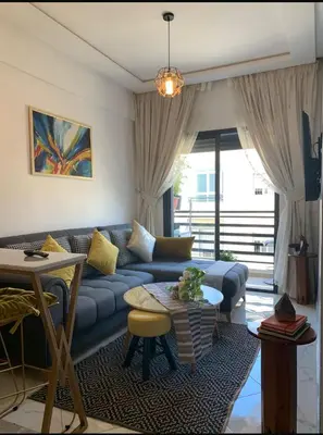 a living room with a blue couch and a table at Hay al qods in Casablanca