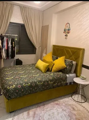 a bedroom with a green bed with yellow pillows at Hay al qods in Casablanca