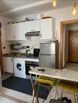 a kitchen with a refrigerator and a table with chairs at Hay al qods in Casablanca