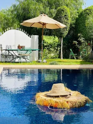 a straw hat is sitting on top of a pool at Villa with rooftop bar overlooking sea, pool & vegetable garden in Tamaris