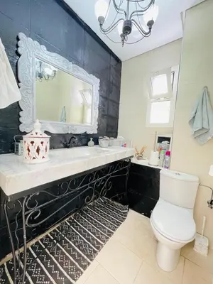 a bathroom with a sink and a toilet and a mirror at Villa with rooftop bar overlooking sea, pool & vegetable garden in Tamaris