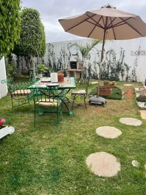 a table and chairs with an umbrella in a yard at Villa with rooftop bar overlooking sea, pool & vegetable garden in Tamaris